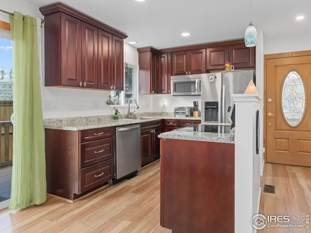 a kitchen with granite countertop a sink stove and cabinets