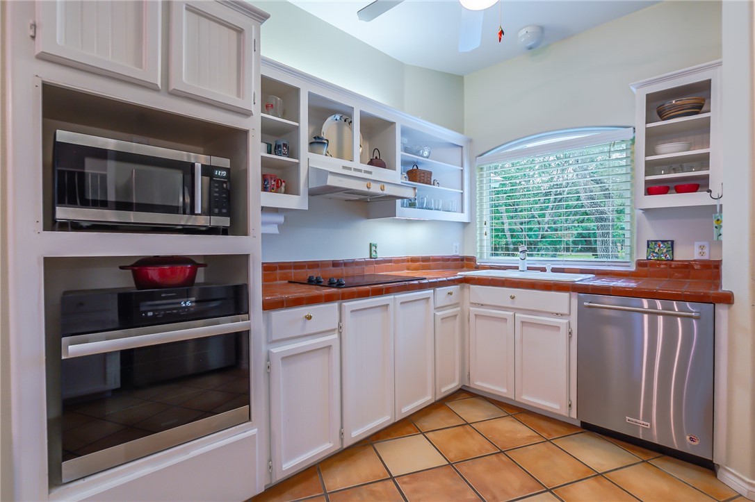 610 Bent Tree Street Rockport, TX 78382 - Photo 22 of 40 a kitchen with stainless steel appliances a stove and cabinets