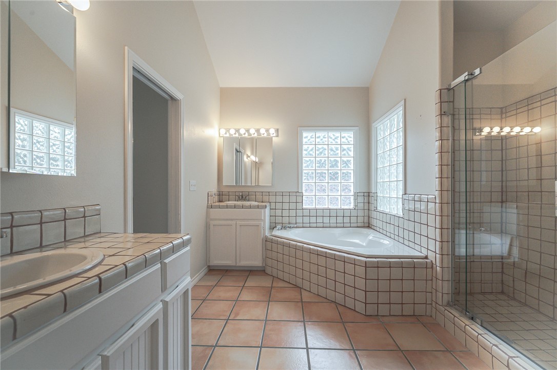 610 Bent Tree Street Rockport, TX 78382 - Photo 30 of 40 a bathroom with a tub a sink a mirror and a shower