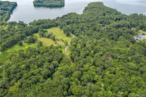 an aerial view of residential house with outdoor space and trees all around