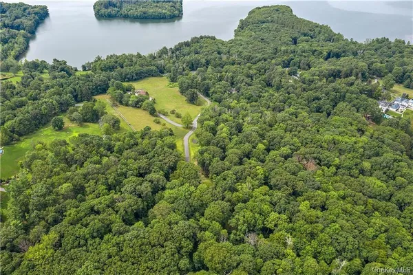 an aerial view of residential house with outdoor space and trees all around