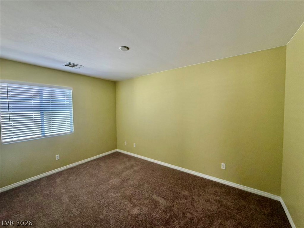 7326 Dicentra Road Las Vegas, NV 89113 - Photo 14 of 18 Plush carpeting anchors this versatile room under a smooth ceiling with a wide window.