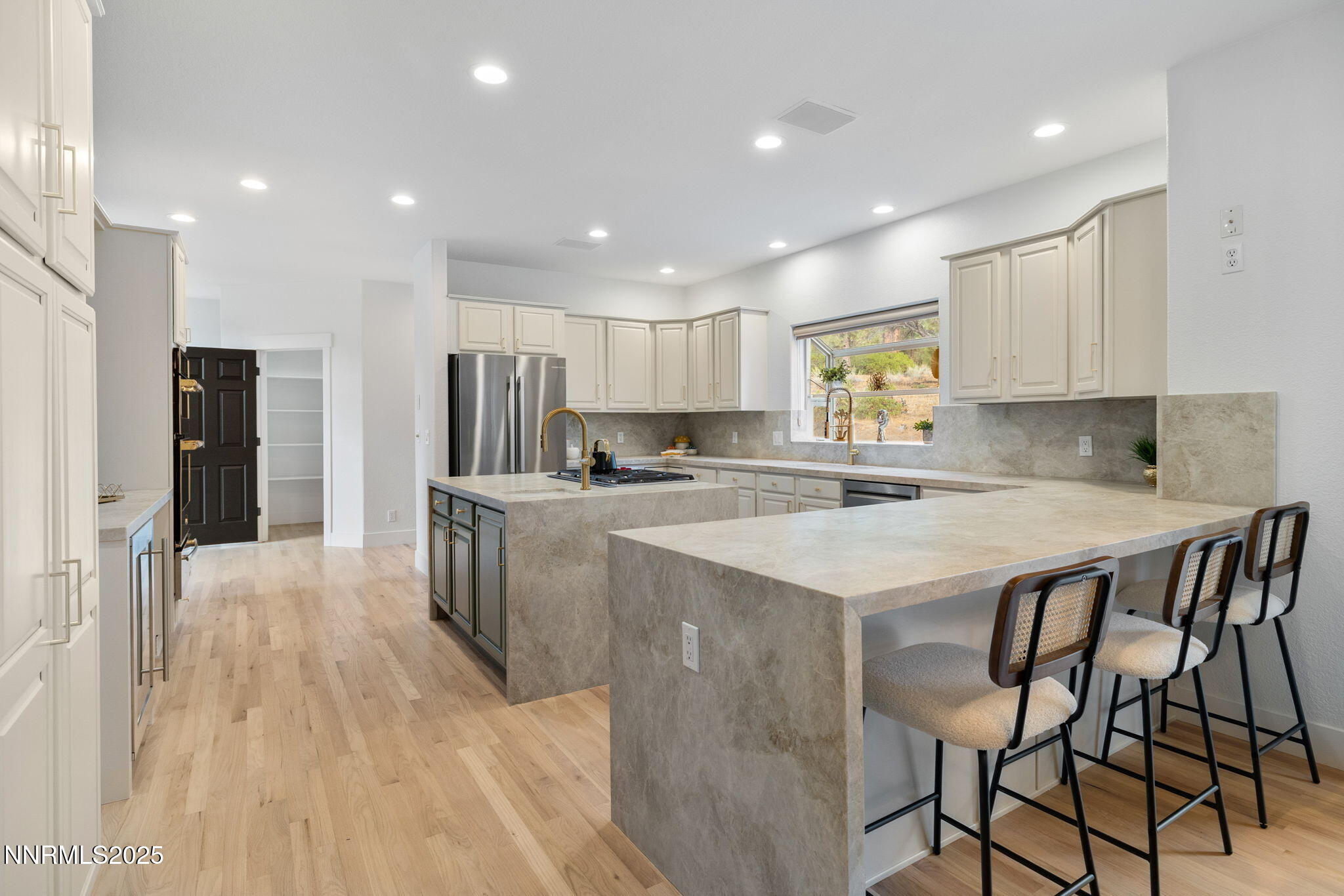16435 Snow Flower Drive Reno, NV 89511 - Photo 11 of 48 a kitchen with kitchen island granite countertop wooden floors granite top and stainless steel appliances
