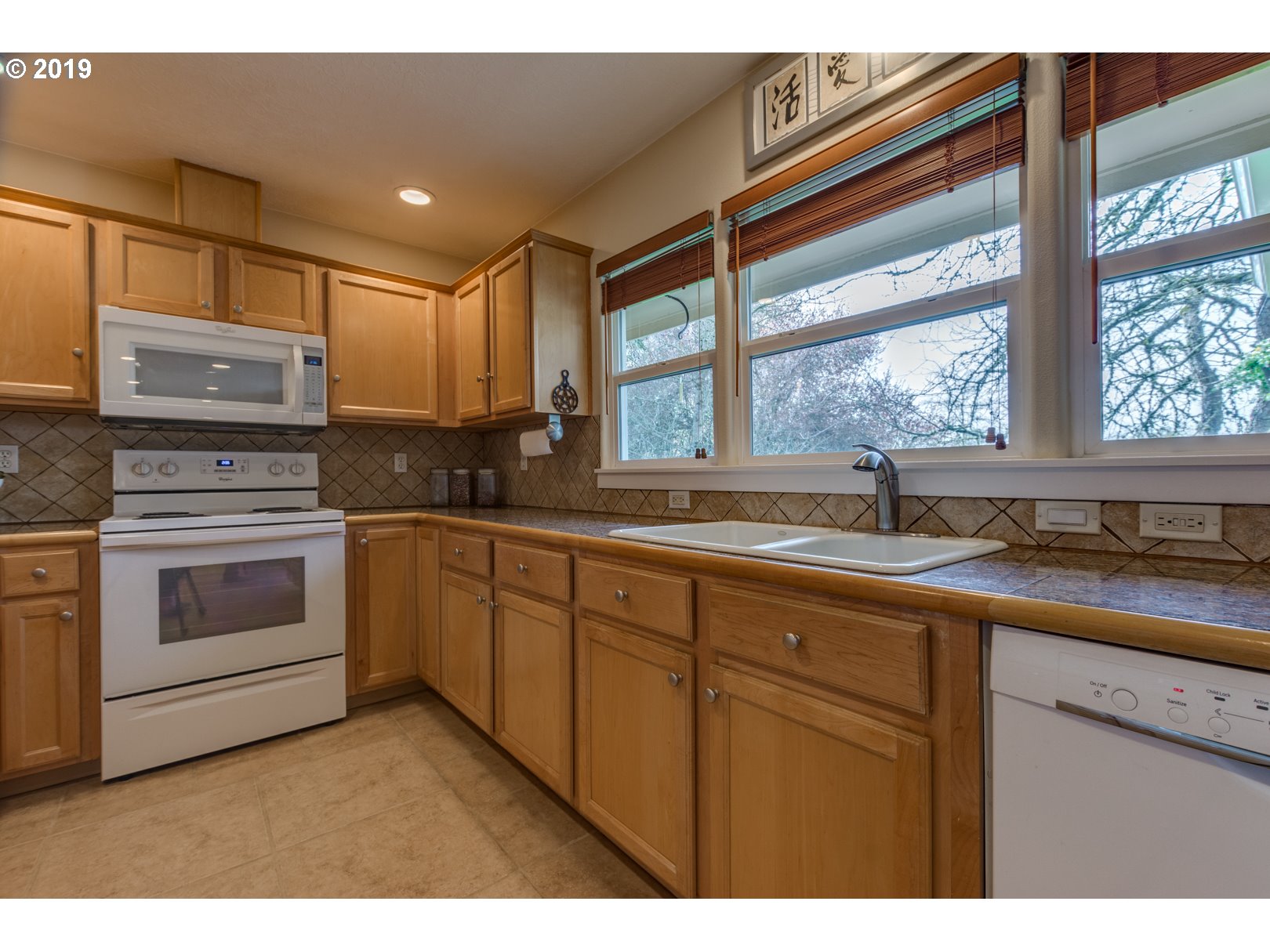 5859 Southwest Oleson Road Portland, OR 97225 - Photo 6 of 32 a kitchen with a sink stove and cabinets