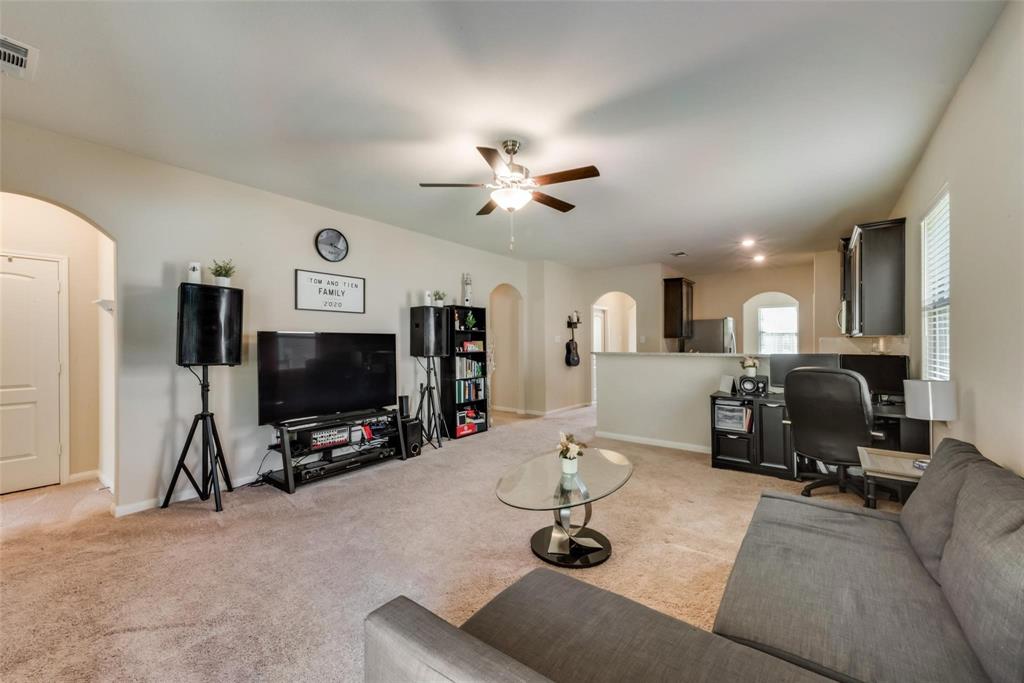 2213 Georgetown Street Princeton, TX 75407 - Photo 13 of 25 Living area featuring arched walkways, light colored carpet, a ceiling fan, and a desk