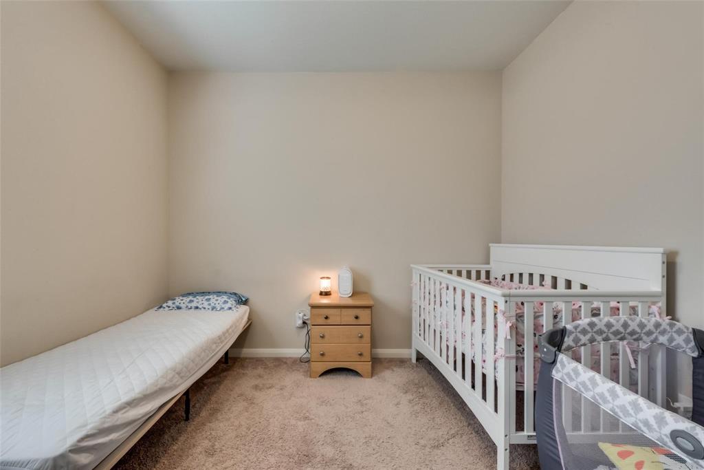 2213 Georgetown Street Princeton, TX 75407 - Photo 22 of 25 Bedroom featuring light colored carpet and a crib