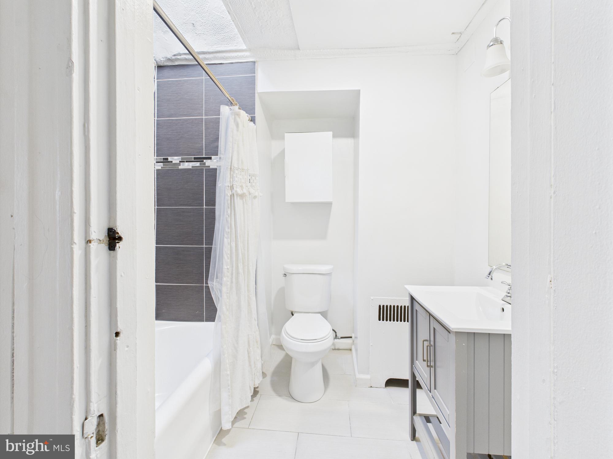 205 East 33rd Street, Unit 3 Baltimore, MD 21218 - Photo 11 of 18 a bathroom with a toilet sink and shower