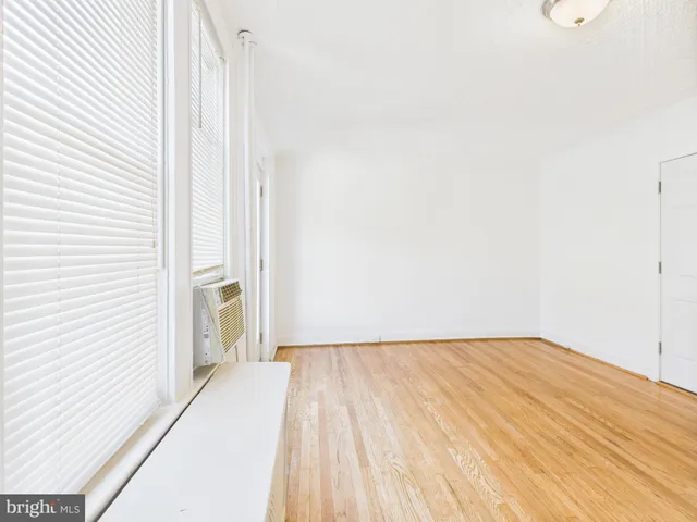 a view of a room with wooden floor and a bathroom
