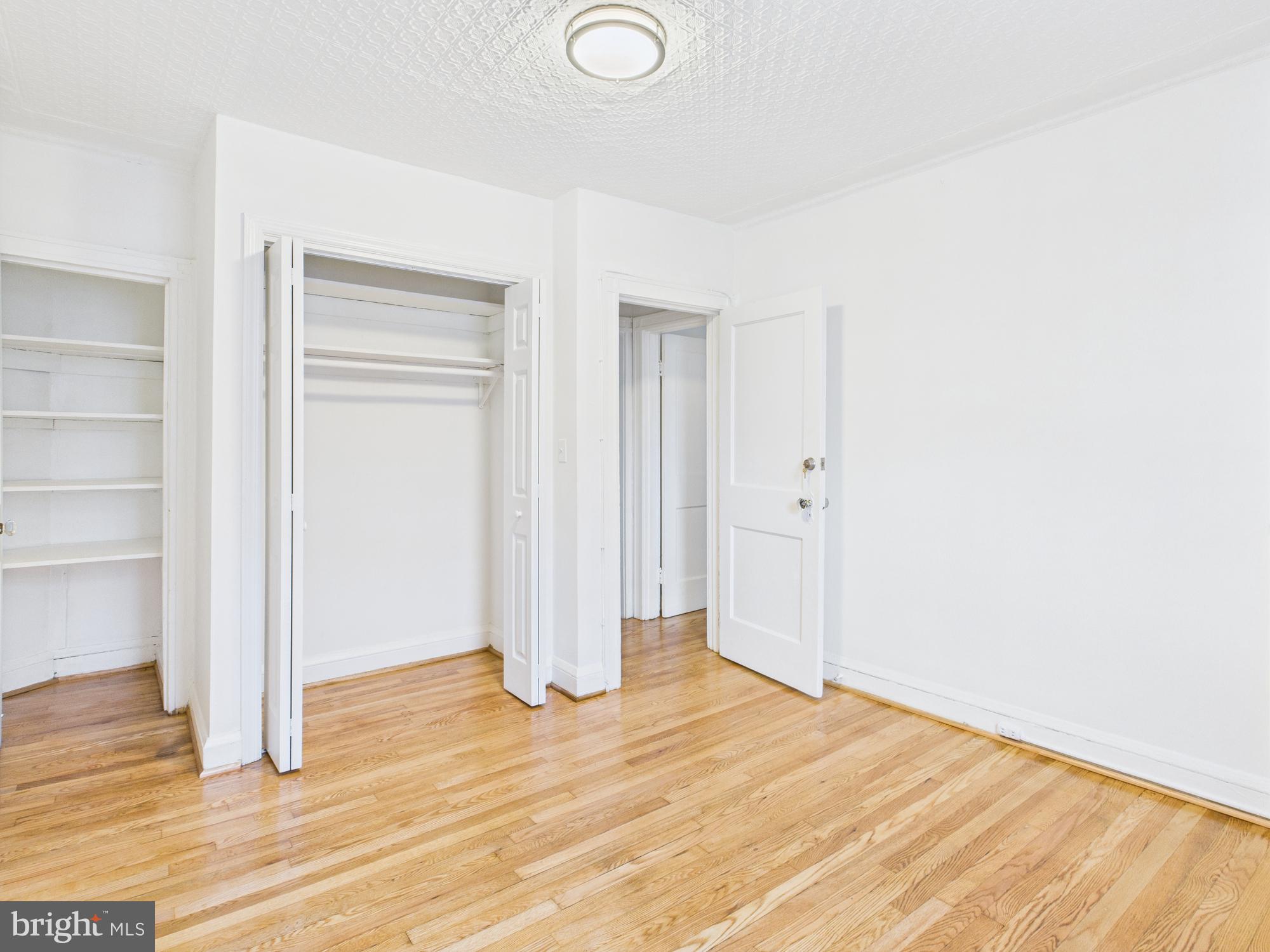 205 East 33rd Street, Unit 3 Baltimore, MD 21218 - Photo 8 of 18 a view of an empty room with wooden floor and a window