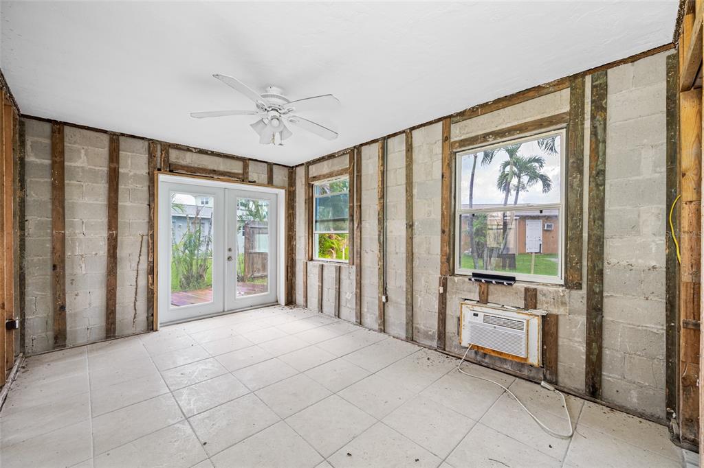 14111 West Parsley Drive Madeira Beach, FL 33708 - Photo 42 of 99 a spacious bedroom with a large bed and a chandelier fan