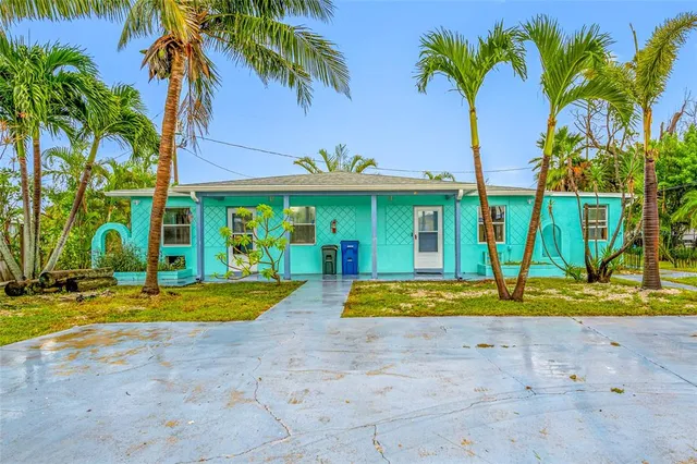 a backyard of a house with table and chairs under an umbrella