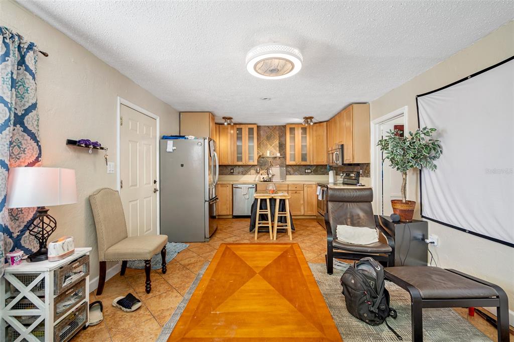 14111 West Parsley Drive Madeira Beach, FL 33708 - Photo 80 of 99 a living room with furniture and a dining table with kitchen appliances