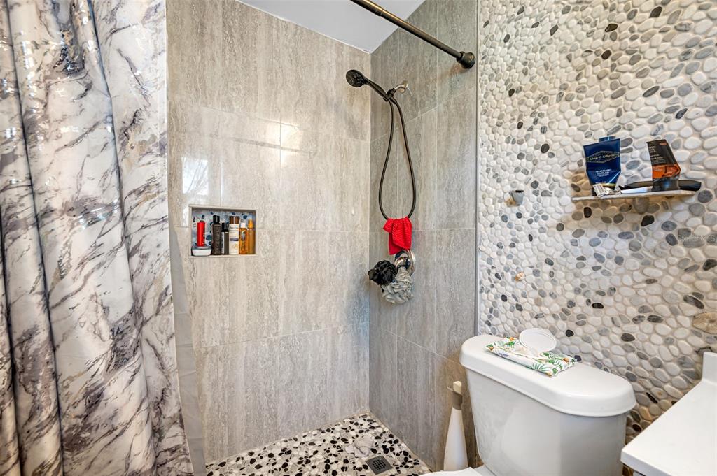 14111 West Parsley Drive Madeira Beach, FL 33708 - Photo 96 of 99 a bathroom with a toilet and a shower curtain