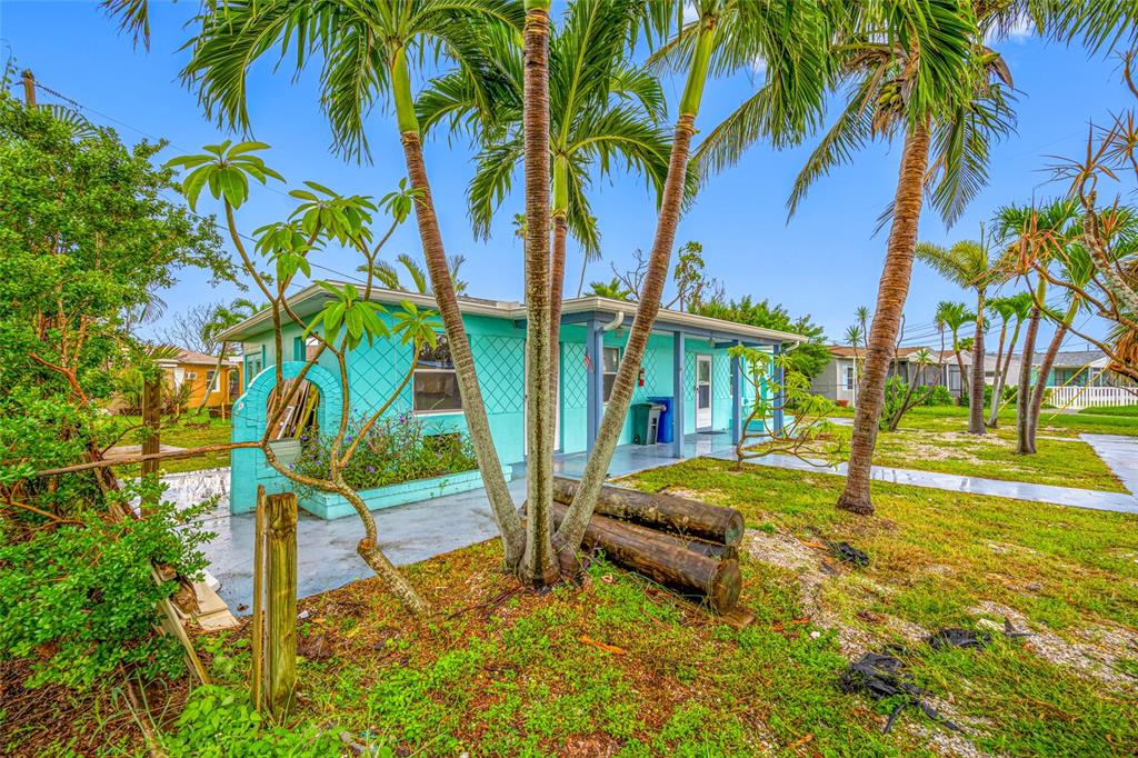 14111 West Parsley Drive Madeira Beach, FL 33708 - Photo 10 of 99 a backyard of a house with table and chairs under an umbrella