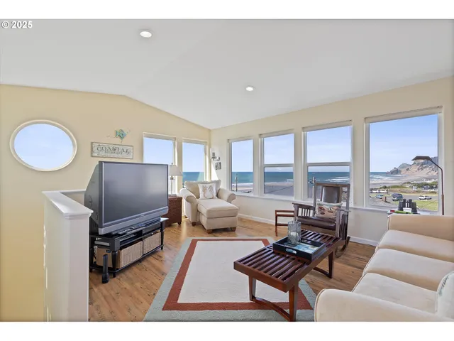 a living room with furniture a flat screen tv and kitchen view