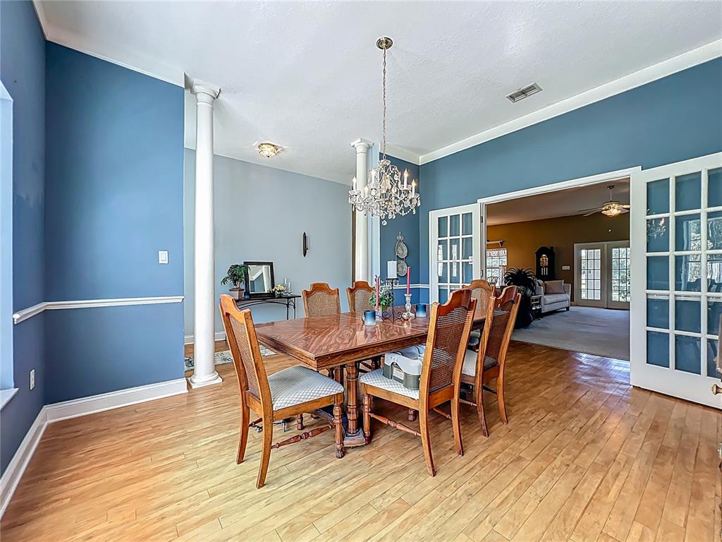 10222 Rockridge Road Lakeland, FL 33810 - Photo 15 of 39 a dining room with furniture a chandelier and wooden floor