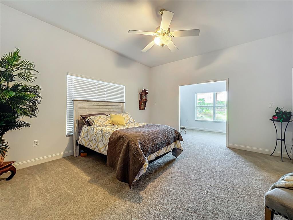 10222 Rockridge Road Lakeland, FL 33810 - Photo 17 of 39 a spacious bedroom with a bed and a chandelier