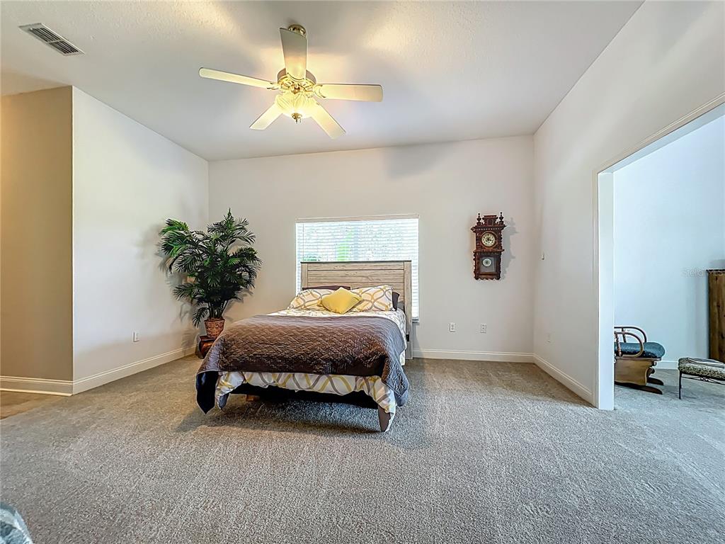 10222 Rockridge Road Lakeland, FL 33810 - Photo 18 of 39 a spacious bedroom with a bed and a chandelier