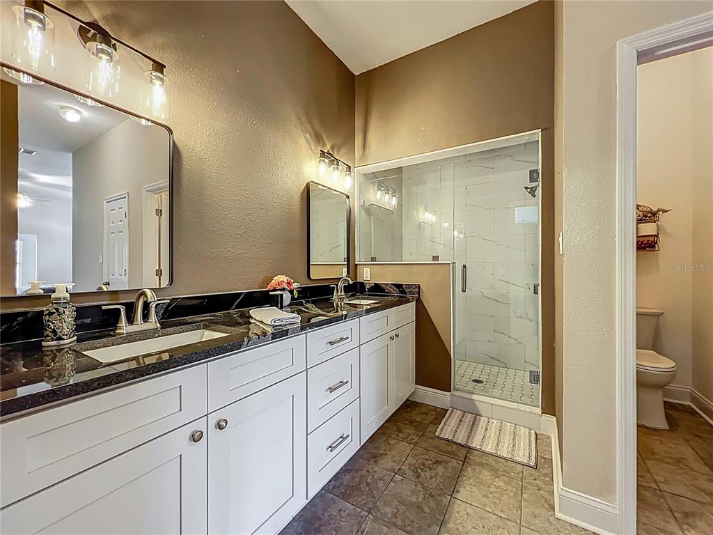 10222 Rockridge Road Lakeland, FL 33810 - Photo 22 of 39 a bathroom with a double vanity sink a toilet and a mirror
