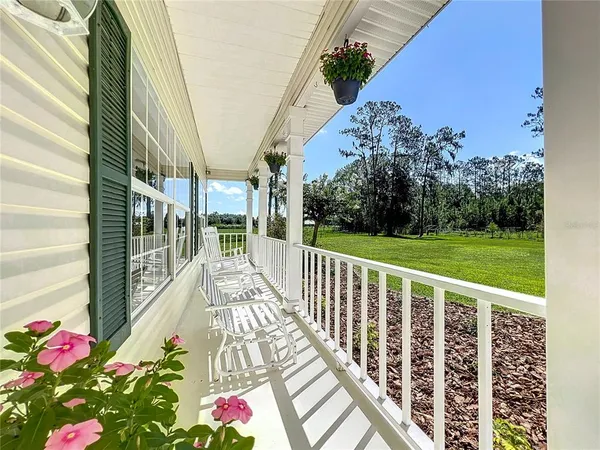 a view of a porch with wooden floor and fence