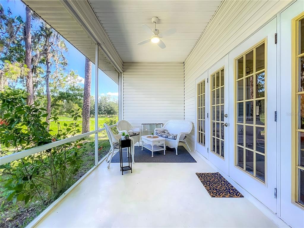 10222 Rockridge Road Lakeland, FL 33810 - Photo 31 of 39 a view of a porch with chairs and floor to ceiling window
