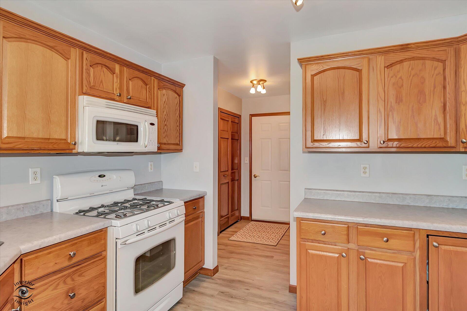 7646 Amanda's Way Crown Point, IN 46307 - Photo 9 of 26 a kitchen with granite countertop cabinets stainless steel appliances and wooden floor