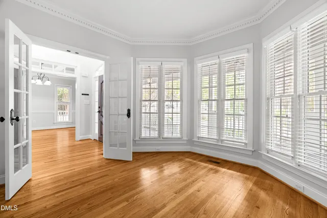 a view of empty room with wooden floor and fan