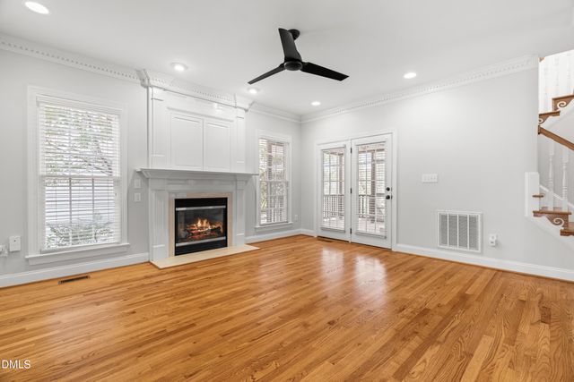 a view of empty room with wooden floor and fireplace