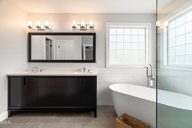 a bathroom with a bathtub a sink and a window