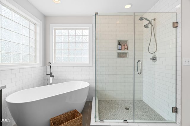 a bathroom with a white bath tub sitting next to a window