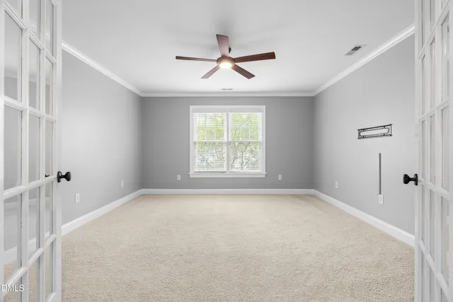 a view of a big room with windows and ceiling fan