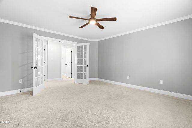 an empty room with chandelier fan