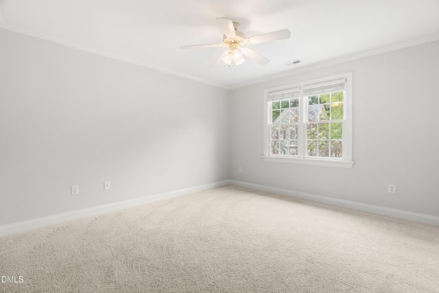 an empty room with windows and ceiling fan