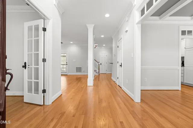 a view of a hallway with wooden floor and staircase
