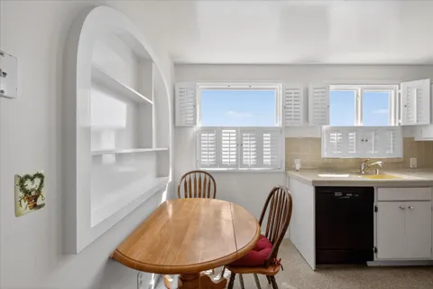 a kitchen with a table chairs sink and cabinets