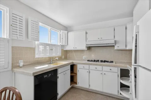 a kitchen with white cabinets stainless steel appliances and sink