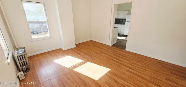 a view of wooden floor and windows in a room