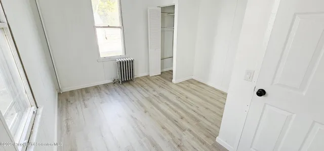 an empty room with wooden floor and a window