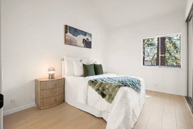 a bedroom with a bed and wooden floor