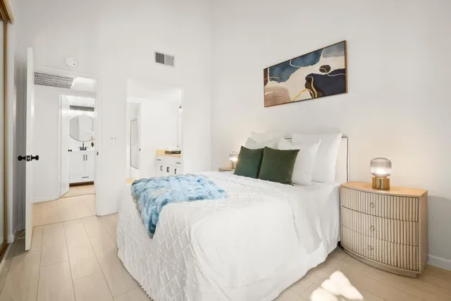 a spacious bedroom with a bed and a cabinets