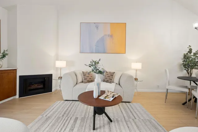 a living room with furniture a fireplace and a potted plant