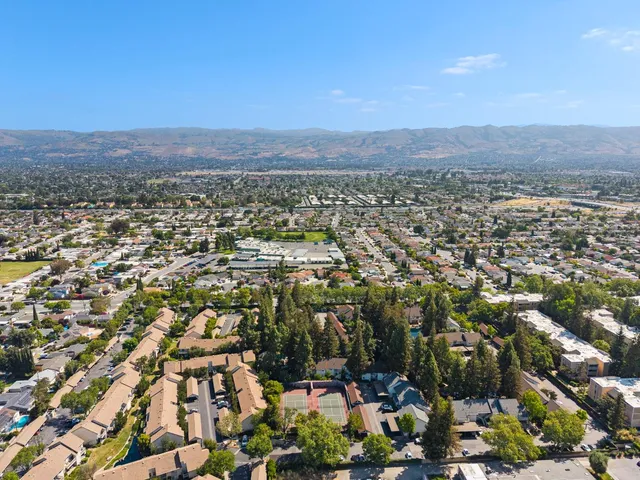 an aerial view of residential houses with outdoor space and trees