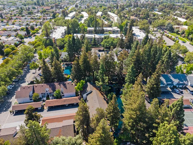 an aerial view of residential house with outdoor space and trees all around
