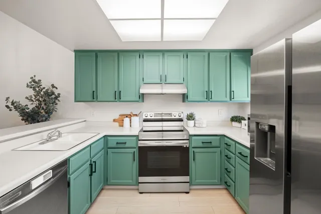 a kitchen with a stove sink and cabinets