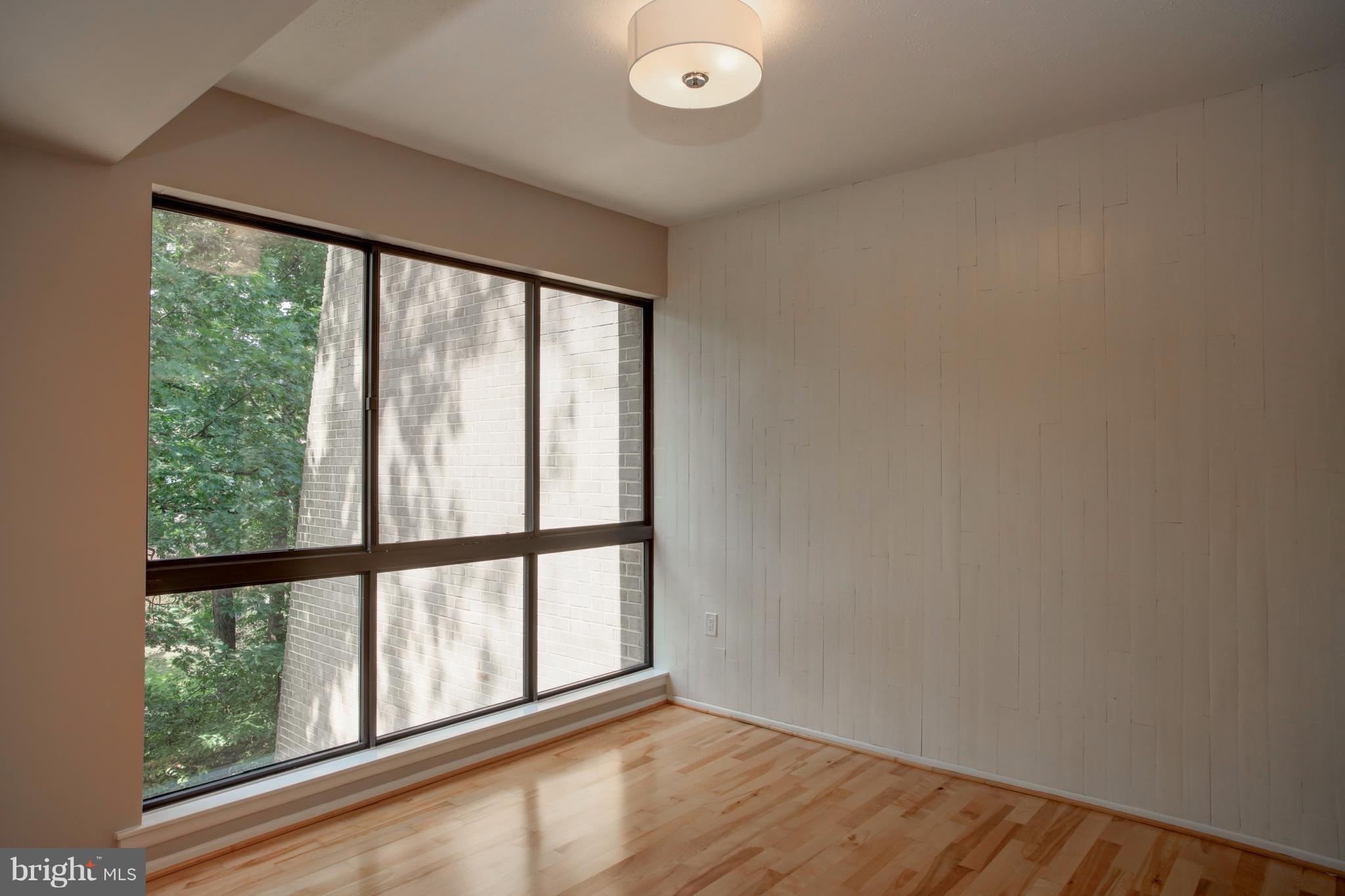 11616 Ivystone Court, Unit 301 Reston, VA 20191 - Photo 9 of 29 a view of an empty room with wooden floor and a window