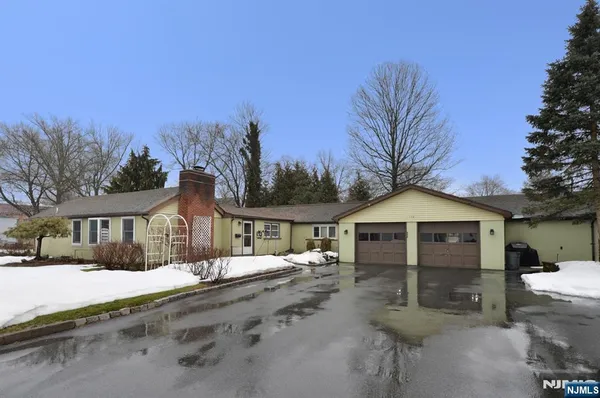 a front view of a house with a yard covered in snow