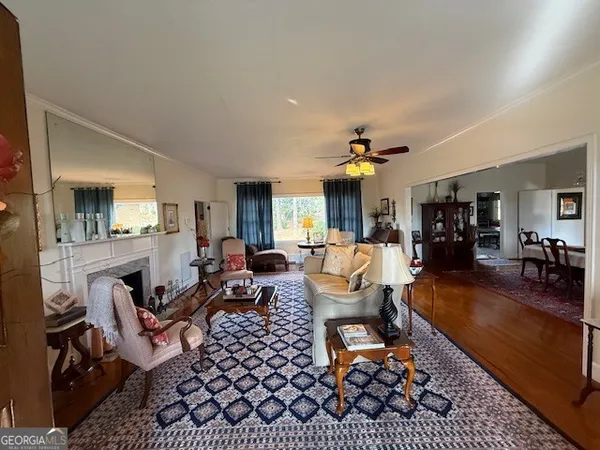 a living room with furniture a dining table and a chandelier