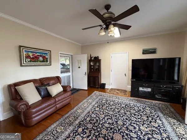 a living room with closet and a flat screen tv