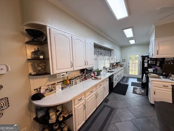 a living room with stainless steel appliances kitchen island a table and chairs