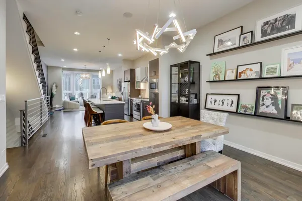 a dining table with wooden floor and stainless steel appliances